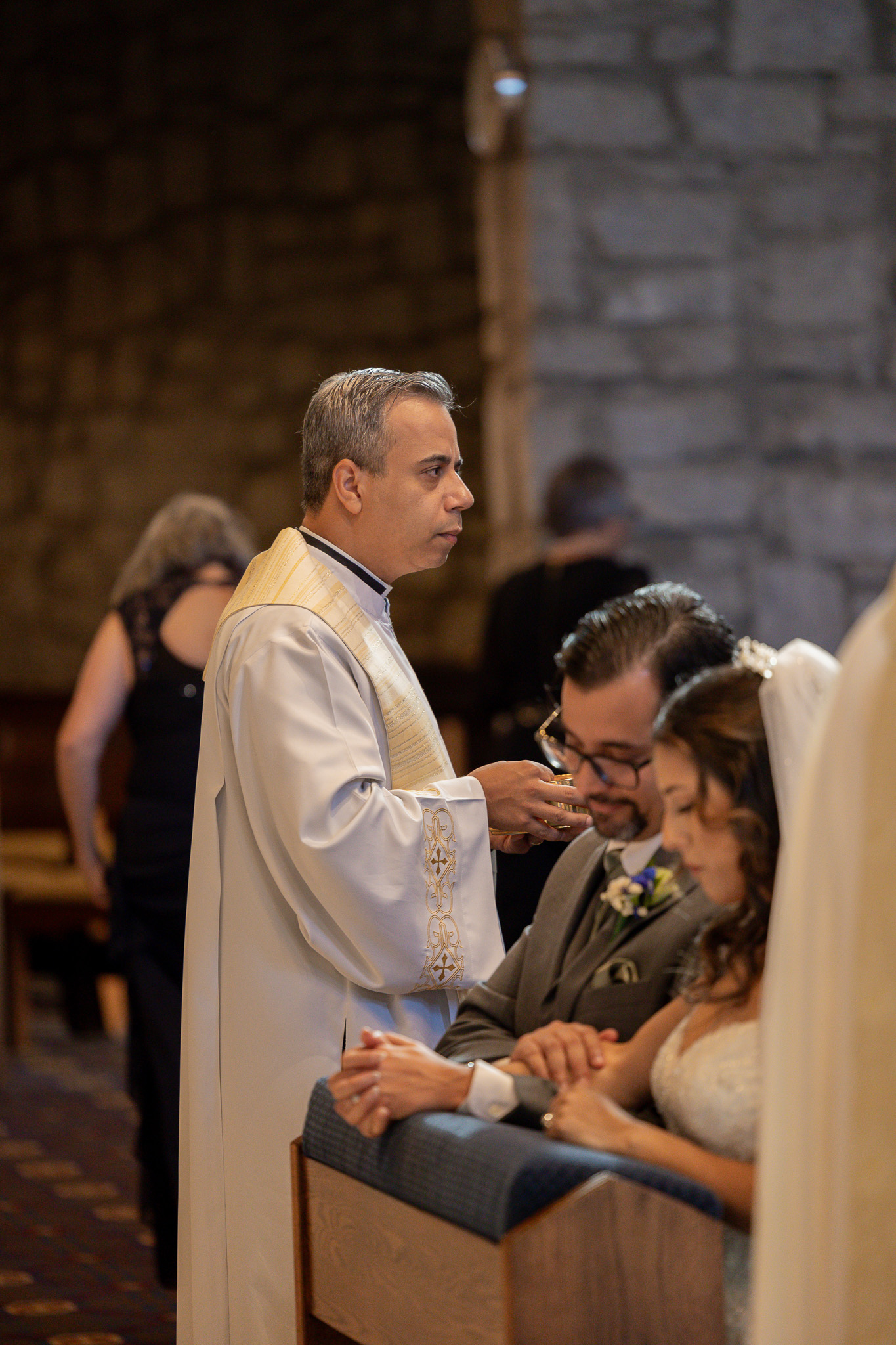 The bride and groom praying with their heads bowed down and eyes closed.