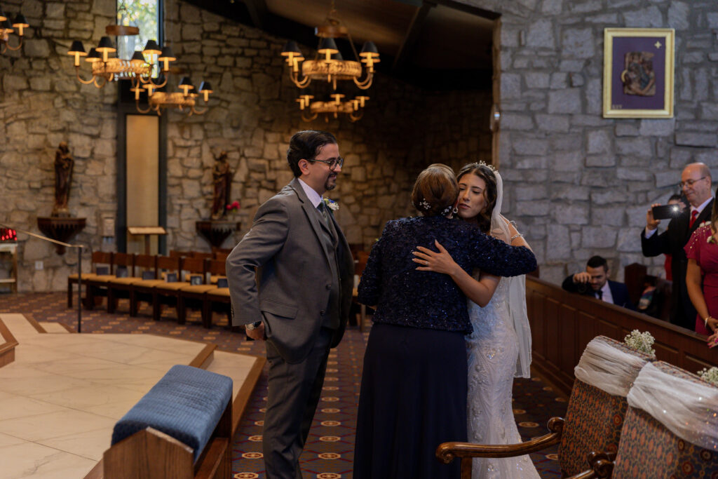 The bride's mother handing off the bride to the groom at the church alter.