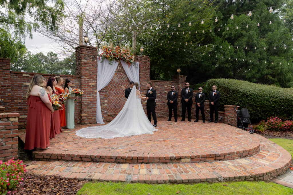 An angled live view of a wedding ceremony at The Carl House's outdoor wedding ceremony site.