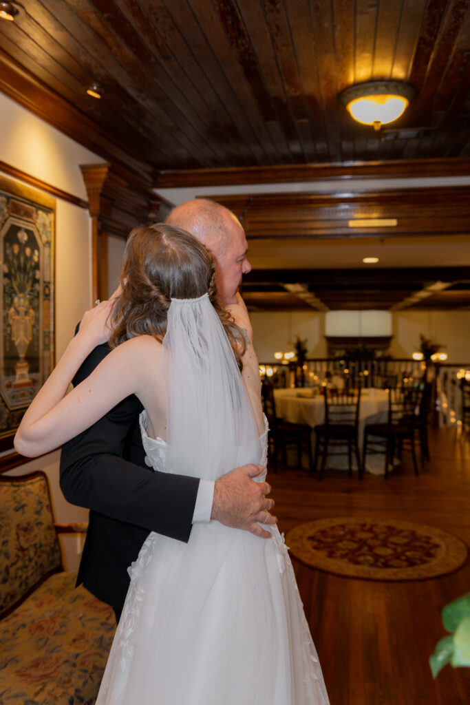 A candid moment between the bride and her father inside the estate.