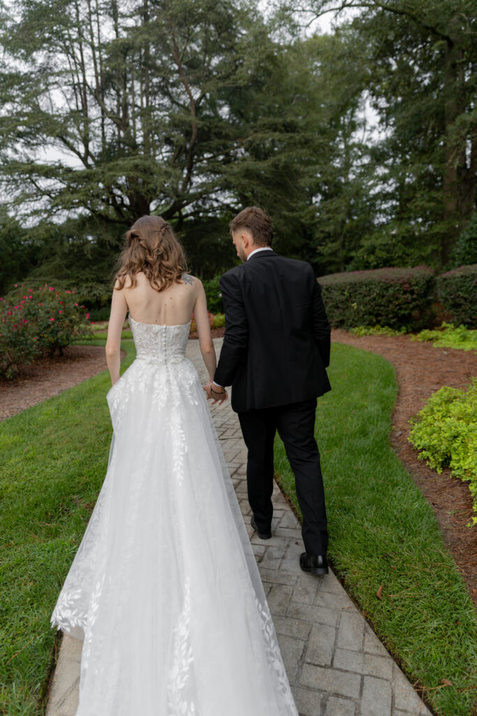 A candid moment of the bride and groom walking away on the brick trail.