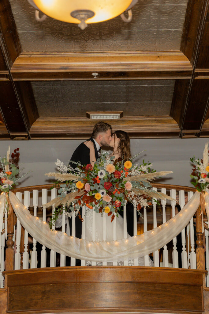 The newly weds kissing and entering the reception space where they are welcomed by the applause and love of their friends and families.