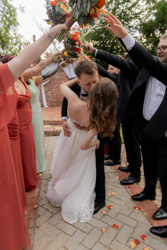 The bride and groom with their wedding party creating a fun tunnel pose.
